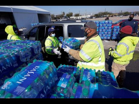 Credit: AP Water is loaded into a vehicle at a City of Houston water distribution site yesterday in Houston. The drive-thru stadium location was setup to provide bottled water to individuals who need water while the city remains on a boil water notice or because they
