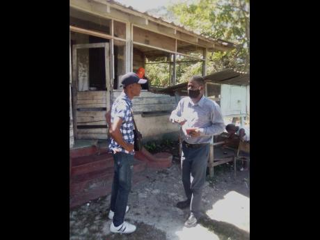 PNP Caretaker for St Catherine South Central Kurt Matthews (right) in dialogue with 71-year-old Hubert Wynter.