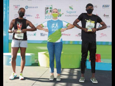 Credit: Contributed Cathy Allen (centre), Sagicor’s chief actuary, congratulates the overall winners in the Sagicor Sigma Run Invitational event, Joanne Harris (left) and distance runner Kevroy Venson from Calabar High School.
