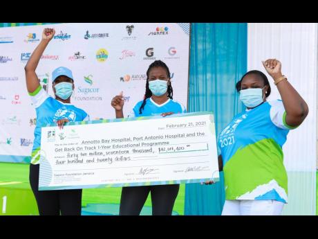 CEOs of the Annotto Bay and Port Antonio hospitals, Marsha Lee (centre) and Althea Gardner (right), pose with their symbolic Sigma Run beneficiary cheques alongside Vice-President of Group Marketing Alysia White. The annual charity event, Sagicor Sigma Run