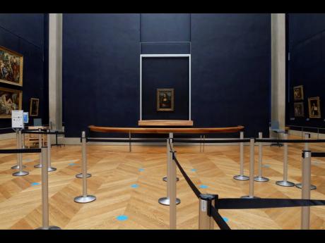 Leonardo da Vinci's 'Mona Lisa' hangs on the wall in a deserted Louvre museum in Paris.