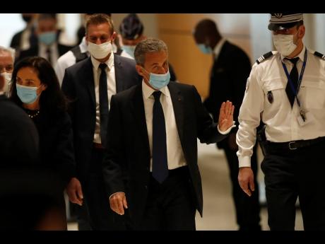 Credit: AP Former French President Nicolas Sarkozy (second right) arrives at the courtroom on March 1 in Paris.