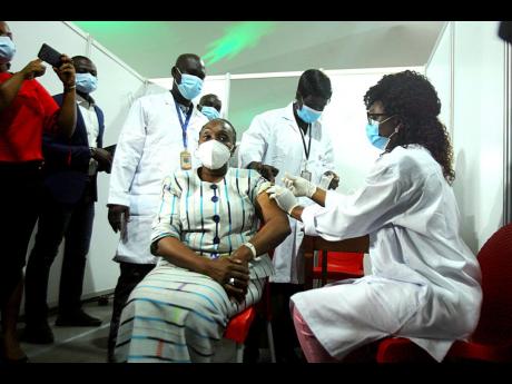 Credit: AP Raimonde Goudou Coffie, culture minister, receives a shot of the AstraZeneca vaccine in Abidjan, Ivory Coast, yesterday. Ivory Coast is the second country in the world after Ghana to receive vaccines acquired through the United Nations-backed COVAX initiat