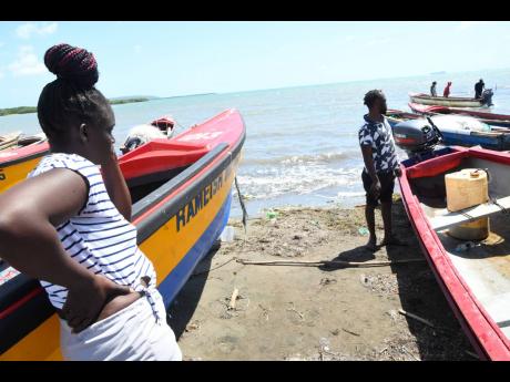 A forlorn Shenel Smith looks out to sea as she awaits news of the continued search for her missing father, Michael Smith, who did not return from his latest trip. Glen Bernard, who was also on the trip, is believed to have been eaten by sharks.