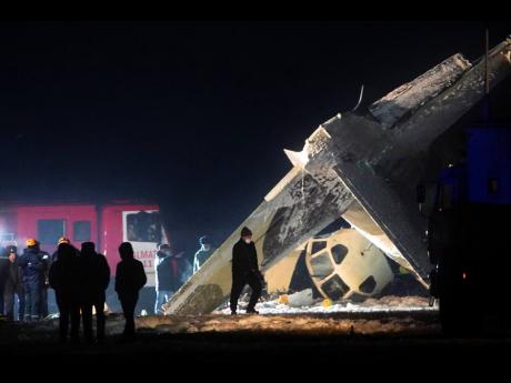 
Emergency employees work at the side of the crashed Soviet-built An-26 two-engine turboprop at the airport of Kazakhstan’s largest city, Almaty, Kazakhstan, Saturday, March 13, 2021.