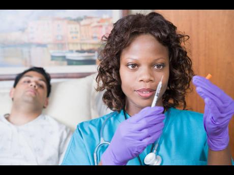 A nurse readies an injection to administer to a patient. Nurses from Jamaica are in high demand overseas. It is estimated that more than 70 nurses at the University Hospital of the West Indies have been lured by overseas recruiting agencies since January. 
