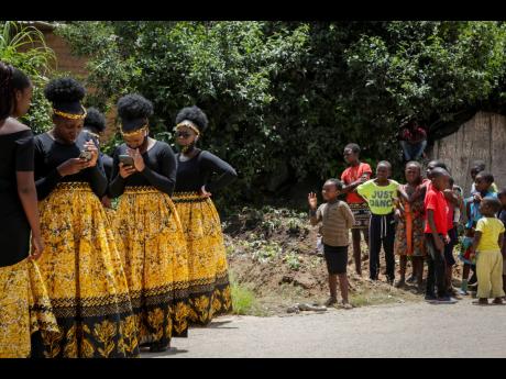 Credit: AP Children watch bridesmaids as they check their phones at a traditional marriage ceremony in the capital Harare, Zimbabwe. Many people across Africa are rethinking big, bountiful weddings amid the economic ravages of COVID-19, and the coronavirus pandemic i