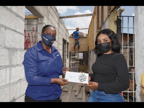Ayana Humber (right), receives her cheque for $150,000 from NCB Foundation’s Zonya Pryce. 