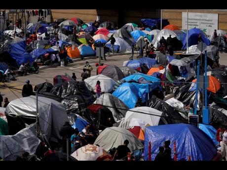 
A makeshift camp of migrants sits at the border port of entry leading to the United States, Wednesday, March 17, 2021, in Tijuana, Mexico.
