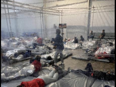 This March 20, 2021 photo, provided by the Office of Representative Henry Cuellar, Democrat from Texas, shows detainees in a Customs and Border Protection temporary overflow facility in Donna, Texas.