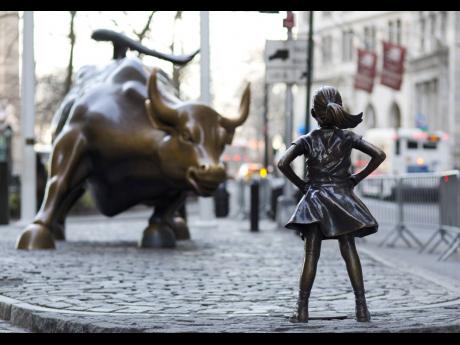 In this March 22, 2017 photo, the Charging Bull and Fearless Girl statues sit on Lower Broadway in New York. New investors have been entering the market since the pandemic.