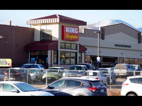 Credit: AP A makeshift fence stands around the parking lot outside a King Soopers grocery store on Tuesday, March 23, where a mass shooting took place a day earlier in Boulder, Colorado.