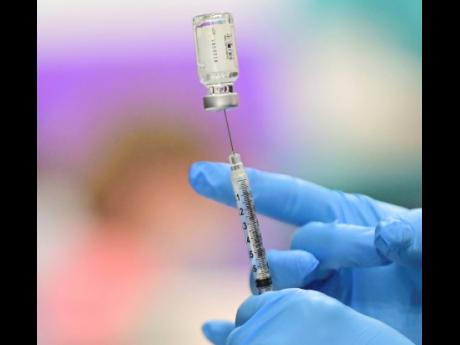 A nurse prepares a dose of COVID-19 vaccination.