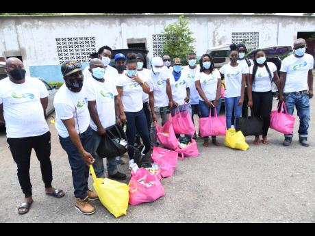 Members of the African Gardens and Bedward Crescent Community Development Foundation prepare to donate care packages to residents in the community on March 30. 