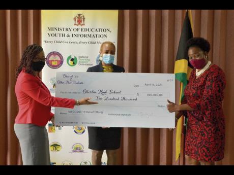 Fayval Williams (centre), minister of education, youth and information, and Nola Wright (left), member of the Oberlin High School Class of 1989 alumni, presents a cheque valued at $600,000 to Michelle Spencer, principal of Oberlin High School. The donation
