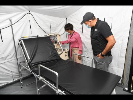 Rudolph Brown/Photographer

Health and Wellness Minister Dr. Christopher Tufton and Dr. Jacqueline Wright James, acting CEO/SMO of the Spanish Town Hospital, examine the sanitizing station on Friday during a tour of the COVID-19 field hospital which was do