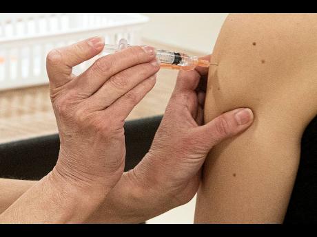 Kent State University student Regan Raeth of Hudson, Ohio, having her COVID-19 vaccination administered by Kent State nurse Kristen Barath in Kent, Ohio. 