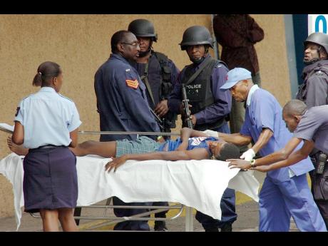 File 
Porters take a young man who had sustained gunshot wounds to the shoulder to the Accident and Emergency Department at the Kingston Public Hospital in this May 2010 photo.