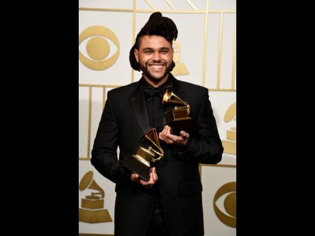 Credit: AP The Weeknd poses in the press room with the awards for Best R&B Performance for 'Earned It (Fifty Shades of Grey)' and Best Urban Contemporary Album for 'Beauty Behind The Madness' at the 58th annual Grammy Awards in Los Angeles in 2016. The Grammy Awards