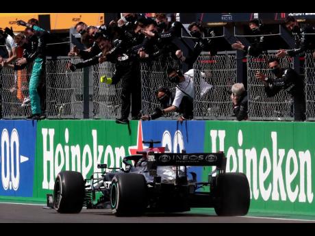 Credit: AP Mercedes driver Lewis Hamilton of Britain crosses the finish line to win the Portugal Formula One Grand Prix at the Algarve International Circuit near Portimao, Portugal, yesterday.