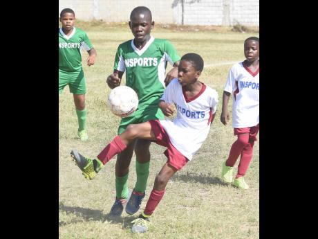 Kimani Reece (right) of York Town brings the ball under control while under pressure from Chadwick Thomas of St Benedict’s in their INSPORTS All-Island Primary School Football quarter-final first leg tie at the Bell Chung Oval on January 28, 2019. The ga