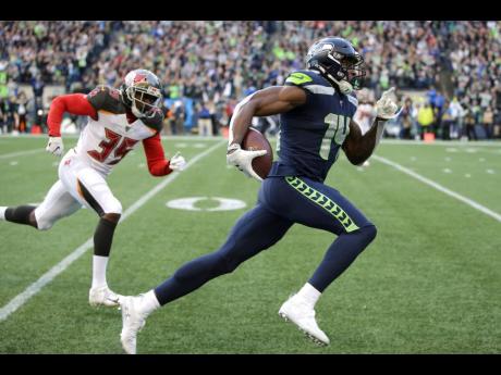 Seattle Seahawks wide receiver DK Metcalf (right) runs to score a touchdown ahead of Tampa Bay Buccaneers defensive back Jamel Dean during the second half of a NFL football game in Seattle, on Sunday, November 3, 2019.