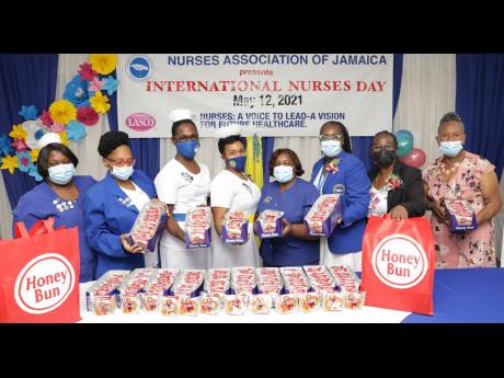 President of the Nurses Association of Jamaica, Patsy Edwards-Henry (third right), surrounded by senior nurses from select health centres across the island, display the delivery of Honey Bun donuts from the baking company’s Donuts for Nurses initiative. 