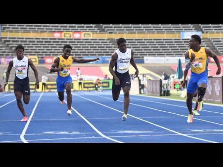 Orlando Wint, 10.79, (right) from St. Elizabeth Technical wins the Class Two boys 100 metres final ahead of Hector Benjamin, 10.74, (second left) from Jamaica College and Javorne Dunkley, 11.01, (left) from St. Elizabeth Technical at the ISSA/GraceKennedy 