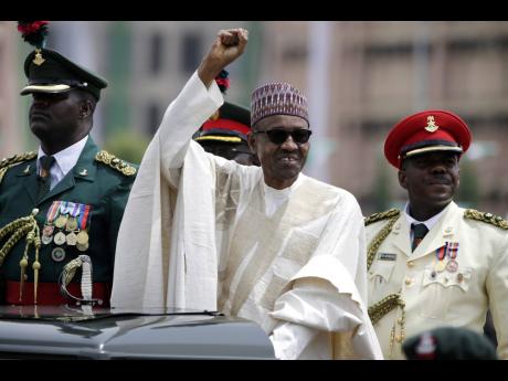 Nigerian President Muhammadu Buhari salutes his supporters during his Inauguration in Abuja, Nigeria, in 2015.
