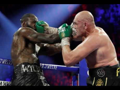 Tyson Fury (right) lands a right to Deontay Wilder during a WBC heavyweight championship boxing match on Saturday, February 22, 2020, in Las Vegas. 