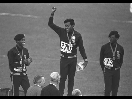 From left: United States runners Larry James, Lee Evans and Ron Freeman are shown after receiving their medals for the 400m race at the Olympic Games in Mexico City in this October 18, 1968 file photo. Evans won gold, James took silver and Freeman got the 