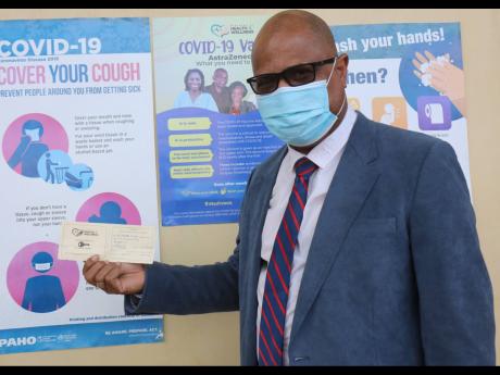 Credit: Ashley Anguin St Andrade Sinclair, acting regional director, Western Regional Health Authority, shows his medical card from taking his second jab of the COVID-19 vaccine on the grounds of the West Jamaica Conference of Seventh-day Adventists Church.