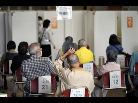 Elderly residents of Sumida Ward wait at the standby station to receive their first dose of Pfizer’s COVID-19 vaccine at the Ryogoku Kokugikan sporting arena in Tokyo on Monday, May 24.