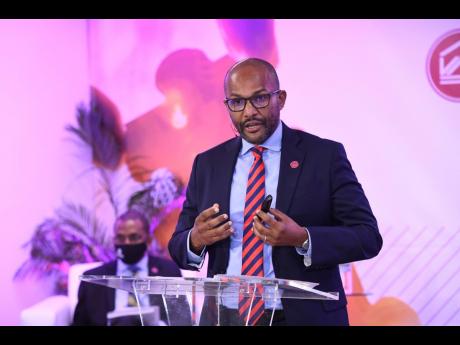 CEO of Victoria Mutual Investments Limited Rezworth Burchenson addresses the company’s annual general meeting on Tuesday, May 25. VM Group President & CEO Courtney Campbell is in the background.