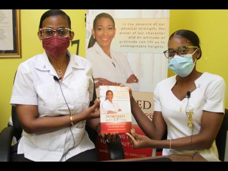Credit: Nathaniel Stewart Dr Marsha Smalling (left), principal of Glenmuir High School and author of the book, ‘Powered Up - Leveraging Six Pillars to Live Out LOUD’ presents a copy of her book to Kerry-Ann Hamilton, school nurse at Central High School in May Pen Clarendon. Bot