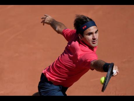 Roger Federer plays a return to Denis Istomin during their first-round match on day two of the French Open tennis tournament at Roland Garros in Paris, France, yesterday. Federer won 6-2, 6-4, 6-3.