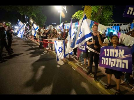 Israeli left-wing protesters chant slogans and hold flags during a demonstration for the forming of a new government in the central Israeli city of Ramat Gan yesterday. Hebrew sign reads: ‘We are the hope’. 