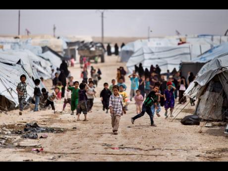 Credit: AP Children gather outside their tents, at al-Hol camp, which houses families of members of the Islamic State group, in Hasakeh province, Syria, recently.