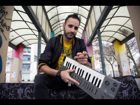 French beatmaker Manudigital poses with another one of his instruments, a model of the Yamaha keyboards. 