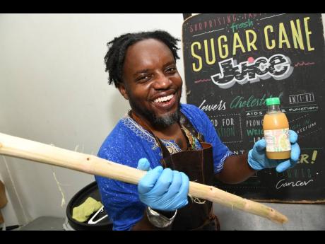 Toussaint Davy, chief juicing officer of Jamaica Cold Pressed Juices, shows off one of his finished products. Inset: Cane juice made by Jamaica Cold Pressed Juices.
