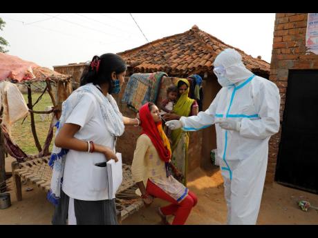 Credit: AP Health workers take nasal swab of a woman to test for COVID-19 in Jamsoti village, Uttar Pradesh state, India, June 8, 2021.