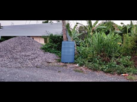 A drum placed along the roadway by a resident who is awaiting the arrival of a water truck.