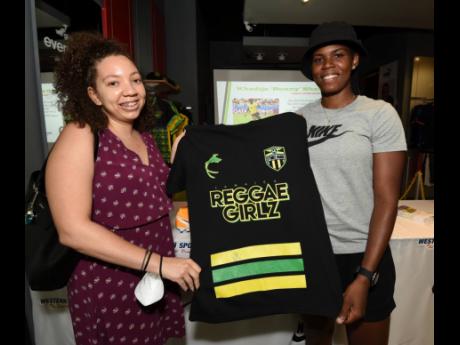 
National striker Khadija Shaw poses with Ashley Codner (left) during a autograph session at the Western Sports store in Tropical Plaza, St Andrew, yesterday.