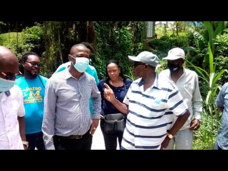 Minister without portfolio in the Ministry of Economic Growth and Job Creation, Everald Warmington (second right), addresses Westmoreland Central Member of Parliament George Wright during a tour of roads in the constituency on Wednesday, June 30. At right 