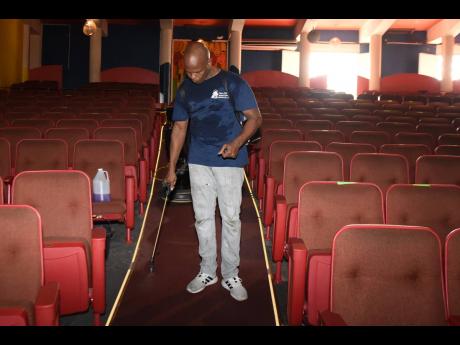 Credit: Kenyon Hemans/Photographer Manpower and Maintenance Services Limited’s Authur Able assists with the cleaning of the Little Theatre.