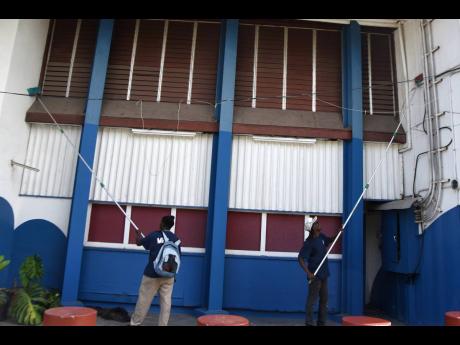 Credit: Kenyon Hemans/Photographer Workmen from Manpower and Maintenance Services Limited were seen cleaning the walls of the Little Theatre on Arthur Wint Drive ahead of the reopening of the entertainment industry.