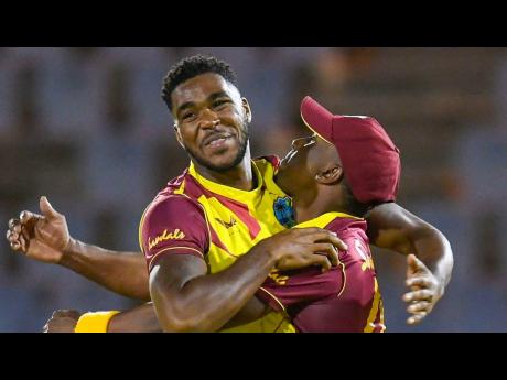 Obed McCoy (left) celebrates with Dwayne Bravo  after taking an Australian wicket during Friday's T20 International at the Daren Sammy Cricket Ground in St Lucia.