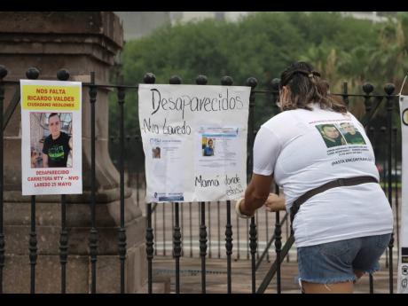 Credit: AP Family of Ricardo Valdes, who disappeared on the road on May 25, places missing posters during a protest in Monterrey, Nuevo Leon state, Mexico, on Thursday.
