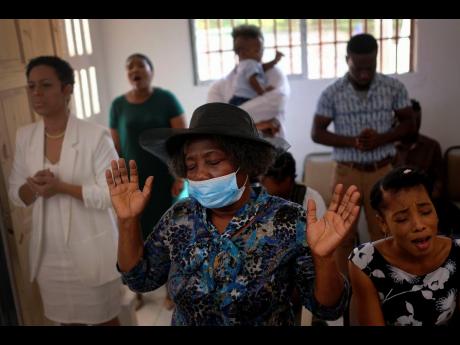 Wearing a face mask against the spread of the new coronavirus, a woman attends Mass in Port-au-Prince, Haiti yesterday.
