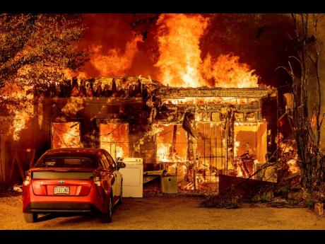 Fire consumes a home as the Sugar Fire, part of the Beckwourth Complex Fire, tears through Doyle, California on Saturday.